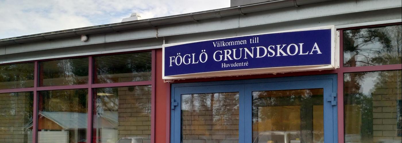 En dörr med skylten "Välkommen till Föglö grundskola"