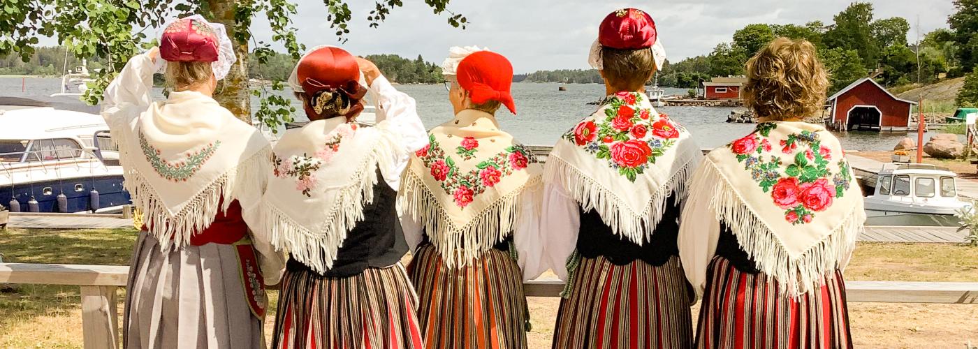 Fem kvinnor ikvällda Föglö folkdräkt.